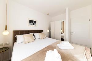 - une chambre avec un grand lit blanc et 2 serviettes dans l'établissement Apartment Borik, à Zadar