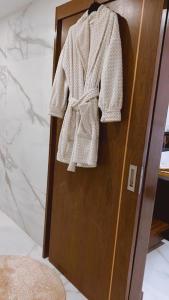 a towel hanging on a door in a bathroom at Pé na Areia in Póvoa de Varzim