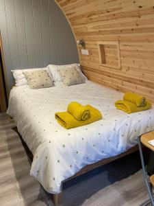 - un lit avec des serviettes jaunes dans l'établissement Glamping Pods, à Milngavie