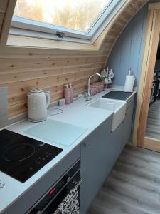 a kitchen with a sink and a window at Glamping Pods in Milngavie