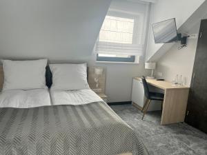 a bedroom with a bed and a desk with a computer at Selavi Jastrzębia in Jastrzębia
