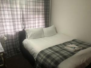 ein kleines Schlafzimmer mit einem Bett und einem Fenster in der Unterkunft Ella's Place in Luton