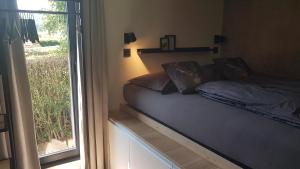 ein Bett in einem Zimmer mit Glasschiebetür in der Unterkunft O'Noire, Viroinval Treignes in Treignes