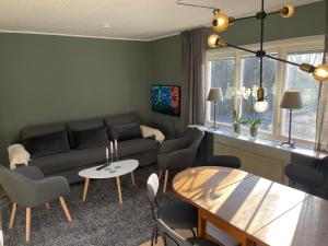 a living room with a couch and a table and chairs at New Small house Uppsala in Uppsala