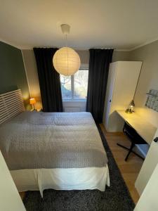 um quarto com uma cama, uma secretária e uma janela em Small house Uppsala em Uppsala