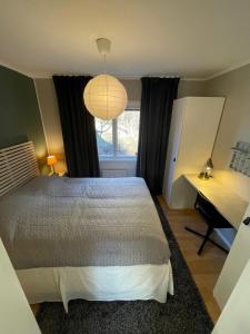 a bedroom with a bed and a desk and a window at New Small house Uppsala in Uppsala