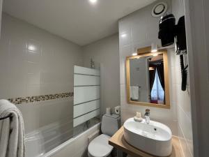 a bathroom with a sink and a toilet and a mirror at Hotel Belfort in Paris