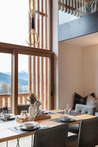 a dining room with a table and a large window at Lerchpeuntgut Alpenfreud Apartments in Tamsweg
