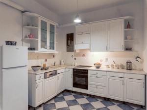 a white kitchen with white cabinets and a refrigerator at Villa Angela in Lastovo +35 photos