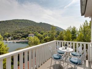 einen Balkon mit einem Tisch und Stühlen sowie Blick auf das Wasser in der Unterkunft Villa Angela in Lastovo