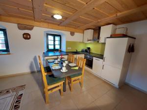 uma cozinha com uma mesa e cadeiras e um frigorífico em Ferienhof Herm em Glashütte