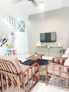 sala de estar con 2 sillas y TV en De'Manda Homestay en Sandakan