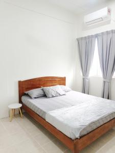 a bedroom with a wooden bed and a window at De'Manda Homestay in Sandakan