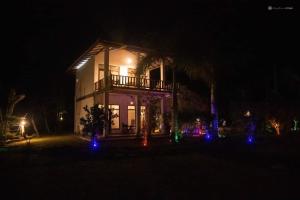 una casa iluminada por la noche con luces azules en ohm lagoon home, en Tangalle