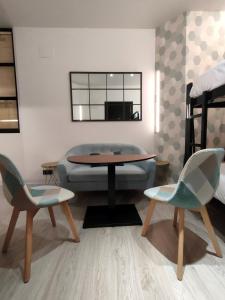 een woonkamer met een tafel en stoelen en een bed bij Apartamentos WUR in Madrid