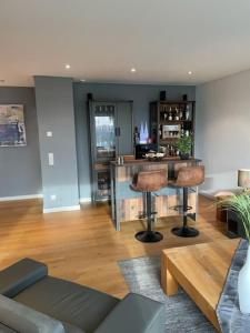 a living room with a bar with stools in it at FlatDeCologne DomBlick in Lohmar