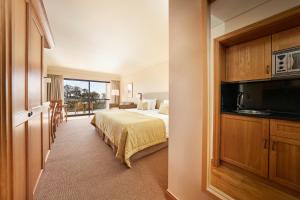 um quarto de hotel com uma cama e uma varanda em The Residence Porto Mare - PortoBay no Funchal