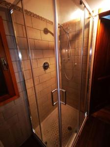 una doccia con porta in vetro in bagno di Villa di montagna sul cammino della Via degli Dei 