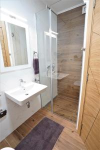 a bathroom with a white sink and a shower at Sky Apartments Novi Sad in Novi Sad
