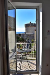 einen Balkon mit einem Tisch und Meerblick in der Unterkunft Apartments Aurelia in Dubrovnik