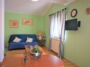 a living room with a blue couch and a table at Apartments Bilic with garden & swimming pool - 50m from the beach in Pješčana Uvala 