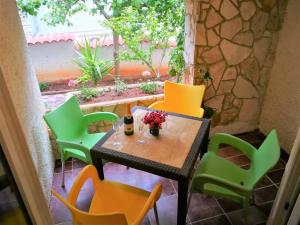 a small table and chairs on a patio at Apartments Bilic with garden & swimming pool - 50m from the beach in Pješčana Uvala 