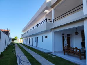 a large white building with a sidewalk and grass at Pousada dos Sonhos Francês in Marechal Deodoro