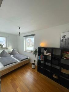 1 dormitorio con 1 cama grande y estante para libros en Apartment AusZeit - Natur Pur - mitten im Grünen, 