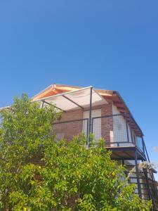 een huis met een balkon bovenop een boom bij Aguila Blanca in Mina Clavero +21 foto's