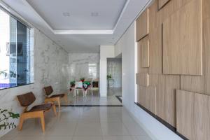 um corredor com armários de madeira e cadeiras numa casa em Hotel Lisbor em Francisco Beltrão