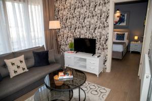 a living room with a couch and a tv at 12 rooms hotel in Köseilyas