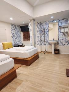 a bedroom with two beds and a sink in it at Sleep Walker Poshtel in Chiang Mai