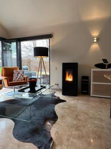 sala de estar con mesa de cristal y chimenea en Sakura Lodging en Bossut-Gottechain