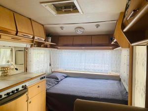 a small bedroom in an rv with a bed in it at Каравана Лили in Varna City