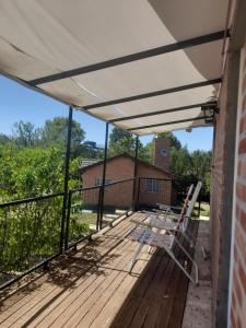 een terras met een witte luifel en stoelen bij Aguila Blanca in Mina Clavero