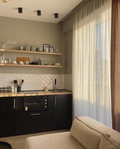 uma cozinha com um sofá, uma janela e um balcão em Square INN Modern Studio City Center em Tirana