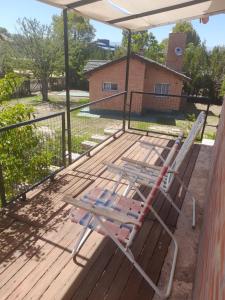 een terras met een loungestoel op een veranda bij Aguila Blanca in Mina Clavero