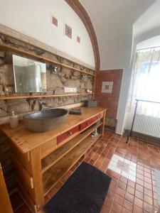 a bathroom with a sink and a stone wall at Apartmány Vila Lucia 2 in Plzeň