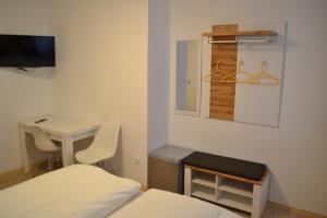 Zimmer mit einem Bett, einem Tisch und einem Schreibtisch in der Unterkunft Platia - rooms in Günzburg
