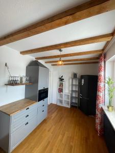 a kitchen with white cabinets and a black refrigerator at Apartment AusZeit - Natur Pur - mitten im Grünen 