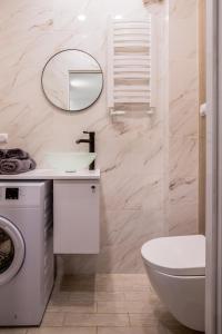 bagno con lavandino e specchio. di Nowoczesny apartament GLAMOUR Łódź z prysznicem pośrodku a Łódź