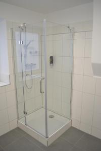 a shower with a glass door in a bathroom at Platia - rooms in Günzburg