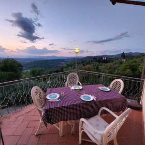 una mesa púrpura y sillas en un balcón con vistas en Villa Tutti i colori del Chianti, en Linari