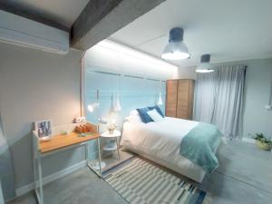 a bedroom with a bed and a desk in it at Morriña Atlantica Loft in Pontevedra