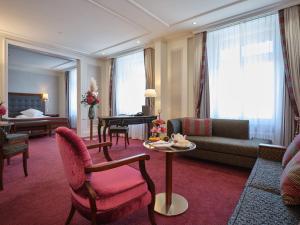 a living room with a couch and a table at The Dufour by Hotel Schweizerhof Zürich in Zürich