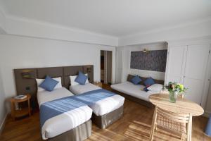 a hotel room with two beds and a couch at Résidence Carlton - Rénovée avec Piscine in Beaulieu-sur-Mer +161 photos