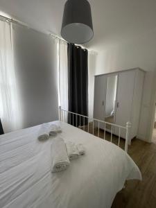 um quarto com uma cama branca e toalhas em Galleria Beta em Trieste