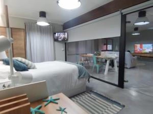 ein Schlafzimmer mit Bett und Tisch und ein Esszimmer in der Unterkunft Morriña Atlantica Loft in Pontevedra