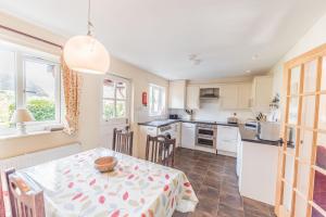 a kitchen and dining room with a table and chairs at Lavender Cottage Coniston in Coniston
