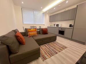 a living room with a couch and a kitchen at Lovely 2 Double Bedroom Flat with free parking - At the Atrium MK in Milton Keynes